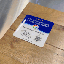 GIF showing a ReviewBoost plaque on a wooden table. The plaque reads